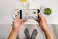 Taking picture of notebook, cake macaron and tea mug on white background. Flatlay