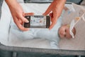 Taking picture by smartphone. Father with his newborn baby is indoors. Conception of single dad Royalty Free Stock Photo