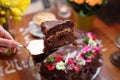 Taking a piece of chocolate cake, carrot cake with chocolate glaze, selective focus, close-up, with blurred background. Royalty Free Stock Photo