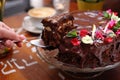 Taking a piece of chocolate cake, carrot cake with chocolate glaze, selective focus, close-up, with blurred background. Royalty Free Stock Photo