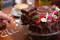 Taking a piece of chocolate cake with chocolate glaze, selective focus, close-up, with blurred background Royalty Free Stock Photo
