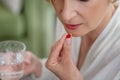 Blonde midaged woman feeling bad and taking a pill Royalty Free Stock Photo