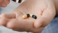 Two big yellow-green cylindrical capsule pills fall into palm of hand from pill bottle. Close-up, front view, center Royalty Free Stock Photo