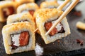 Taking portion of hot crispy tempura maki sushi rolls with cream cheese, raw salmon, tomato and nori seaweed. Royalty Free Stock Photo