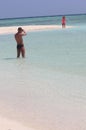 Couple on Vacation Taking Portrait of Wife / Girlfriend in beach water. Located at Sand Bank - Male, Maldives