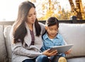 Taking screen time outdoors. an adorable little girl using a digital tablet with her mother on an autumn day outdoors. Royalty Free Stock Photo