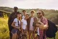 Taking selfie. Group of friends, young men and women walking, strolling together during picnic in summer forest, meadow Royalty Free Stock Photo