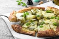 Taking slice of delicious pizza with pesto, cheese and basil on grey table, closeup Royalty Free Stock Photo