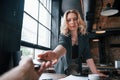 Taking smartphone from the hand of patient. Businesswoman with curly blonde hair indoors in cafe at daytime