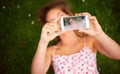 Taking a summer selfie to share with her friends. a young woman taking a selfie while lying on the grass.