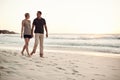 Taking in the sunset. a mature couple taking a stroll on the beach. Royalty Free Stock Photo