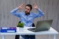 Taking time for a minute break. Cheerful young man holding hands behind head and keeping eyes closed while sitting at his working Royalty Free Stock Photo