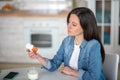 Black-haired womn looking at the pills container