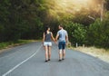 Taking a walk down lovers lane. a happy young couple walking down a road outside. Royalty Free Stock Photo