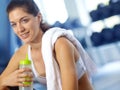 Taking a well-deserved break. A beautiful young woman sitting at the gym taking a break and having a drink of water. Royalty Free Stock Photo