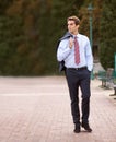 Taking an after-work stroll in the park. A handsome businessman walking outside with his jacket over his shoulder. Royalty Free Stock Photo