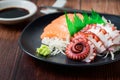 Tako sashimi and Salmon on black dish with chopsticks