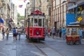The Taksim Tunel Nostalgia Tram trundles along the istiklal street and people at istiklal avenue in centre Istanbul, Turkey