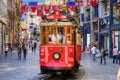 The Taksim Tunel Nostalgia Tram trundles along the istiklal street and people at istiklal avenue