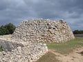 Ruined village of Trepuco Minorca Balearic Islands showing the large taula and surrounding stone wall Royalty Free Stock Photo