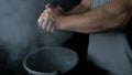 Talc sports. Closeup of a muscular man ready to workout. male powerlifter hand in talc and sports wristbands preparing