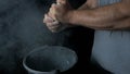 Talc sports. Closeup of a muscular man ready to workout. male powerlifter hand in talc and sports wristbands preparing