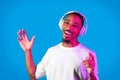 Talented african american guy singing songs, using wireless headphones Royalty Free Stock Photo