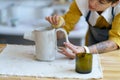 Talented artisan at work: pottery artist female shaping ceramic jug from raw clay in workshop studio Royalty Free Stock Photo