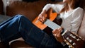 Talented and calm young asian girl laying on sofa and playing a classic guitar Royalty Free Stock Photo