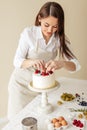 Talented chef covering dessert with sweet fresh berries