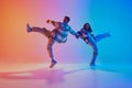 Talented and creative freestyle dancers performing in motion against gradient studio background. Synchronized movements. Royalty Free Stock Photo