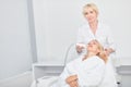 Talented experienced cosmetologist improving the face of female blonde client Royalty Free Stock Photo