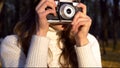 Talented girl taking pictures of beautiful autumn nature on old vintage camera Royalty Free Stock Photo