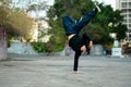 Talented male hip hop dancer doing a handstand in urban area