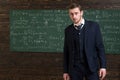 Talented mathematician. Man formal wear classic suit looks smart, chalkboard with equations background. Genius solved