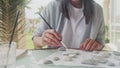 Talented painter looking nature drawing picture outdoor. Portrait of creative girl painting rocks in windy day