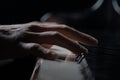 Talented pianist plays classical melody on piano in the dark. Detailed close up shot of a mans hands touches the white Royalty Free Stock Photo