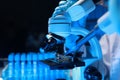 A talented scientist sits in his lab while using a microscope to look for microscopic organisms in a test sample, microscope It is