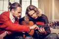 Bearded guitar tutor feeling busy teaching his talented student