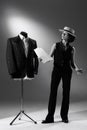 Portrait of talented woman, fashion designer standing near mannequin with stylish classic male suit. Black and white Royalty Free Stock Photo