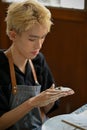 A talented young Asian gay man focuses on molding raw clay with his hands Royalty Free Stock Photo