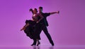 Talented young man and woman, professional dancers performing tango over purple background on neon lights. Concept of Royalty Free Stock Photo