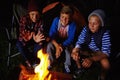Tales around the campfire. three young boys sitting by the campfire. Royalty Free Stock Photo
