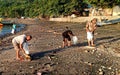 Three men collecting plastic trash on the beach