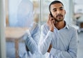 Talk to me. a handsome young businessman talking on his cellphone in the office. Royalty Free Stock Photo