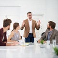 Talking business with the team. a businessman giving a presentation to colleagues sitting at a table in a modern office. Royalty Free Stock Photo