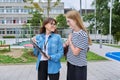 Talking teacher and teenage schoolgirl outdoor, school building background Royalty Free Stock Photo