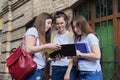 Talking group of student girls, teenage girls college students near brick building Royalty Free Stock Photo