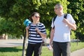 Talking middle-aged man and woman, couple walking along park road Royalty Free Stock Photo