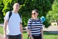 Talking middle-aged man and woman, couple walking along park road Royalty Free Stock Photo